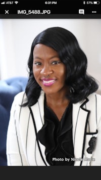 a woman in a white and black blazer is smiling